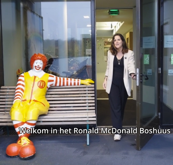 Welkom in het Ronald McDonald Boshuis, met Sanne en het Ronald McDonald-beeld op een bank
